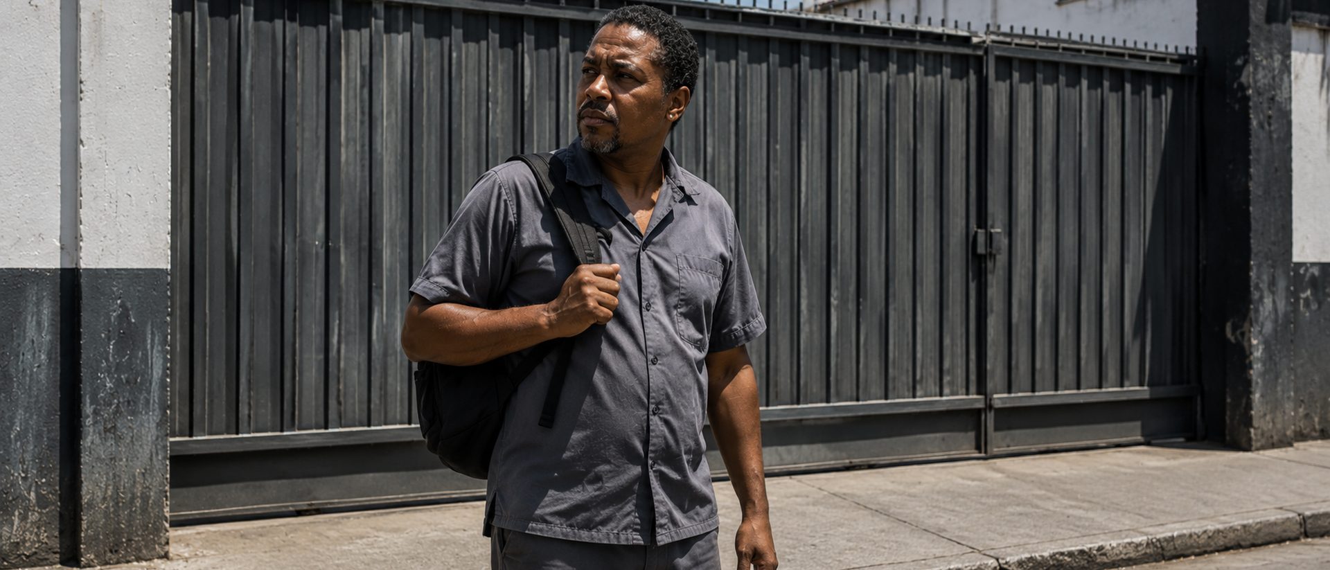 Advogado de reversao de justa causa em Salvador: trabalhador do lado de fora do portao fechado da empresa, com a mochila no ombro